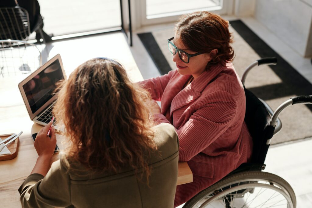 woman in a wheelchair working collaboratively on a laptop