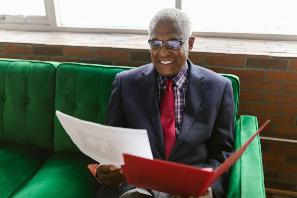 An older man looks at a piece of paper from a file