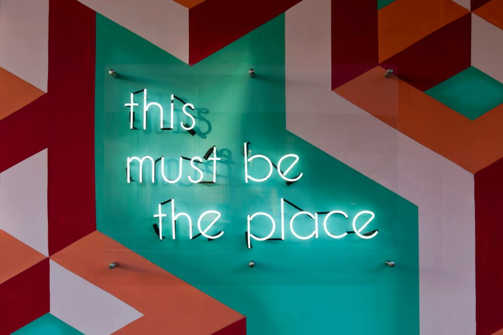 A neon sign reads "this must be the place"
