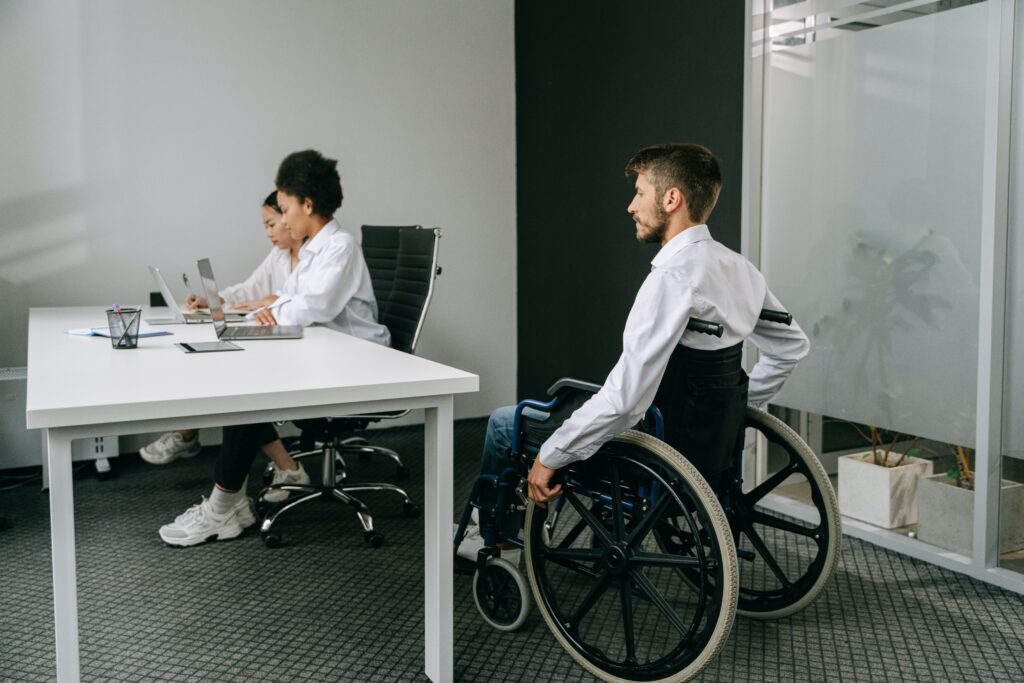 Two empoyees at work being joined by a wheelchair user user