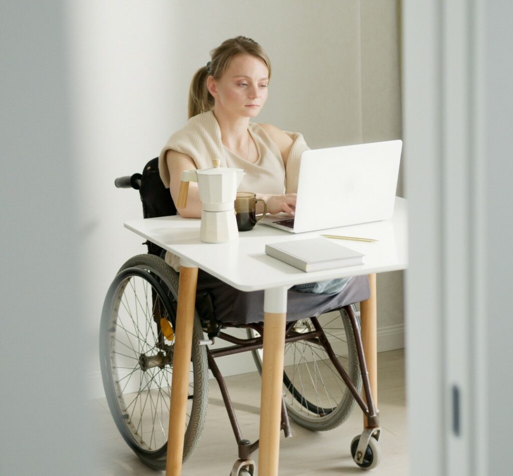 A woman in a wheelchair working from home.